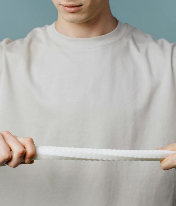 Man in a calm, focused pose against a neutral earthen background.